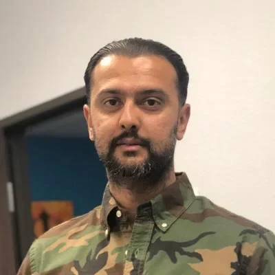 Portrait of Gary, the physical exam manager, wearing a camouflage-patterned shirt.